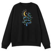 A black oversized crew neck with the Be Magic snake graphic printed large on the front, a blue floral snake with butterflies under a crescent moon.