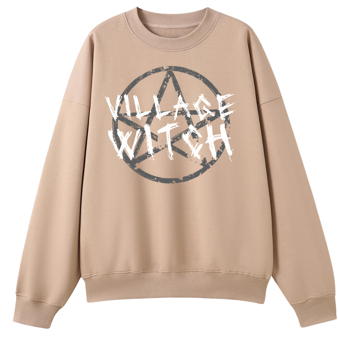 A peach oversized crew neck with the Village Witch graphic printed large on the front, scratchy lettering over a weathered pentagram.