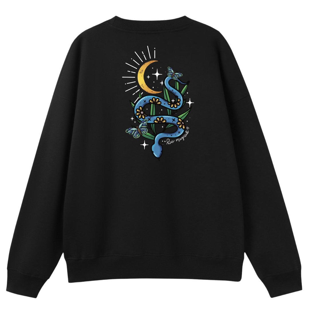 A black oversized crew neck shown from the back, with the Be Magic snake graphic printed large across the back, a blue floral snake with butterflies under a crescent moon.