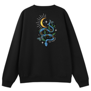A black oversized crew neck shown from the back, with the Be Magic snake graphic printed large across the back, a blue floral snake with butterflies under a crescent moon.