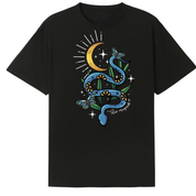 A black oversized tee with the Be Magic snake graphic printed large on the front, a blue floral snake with butterflies under a crescent moon.