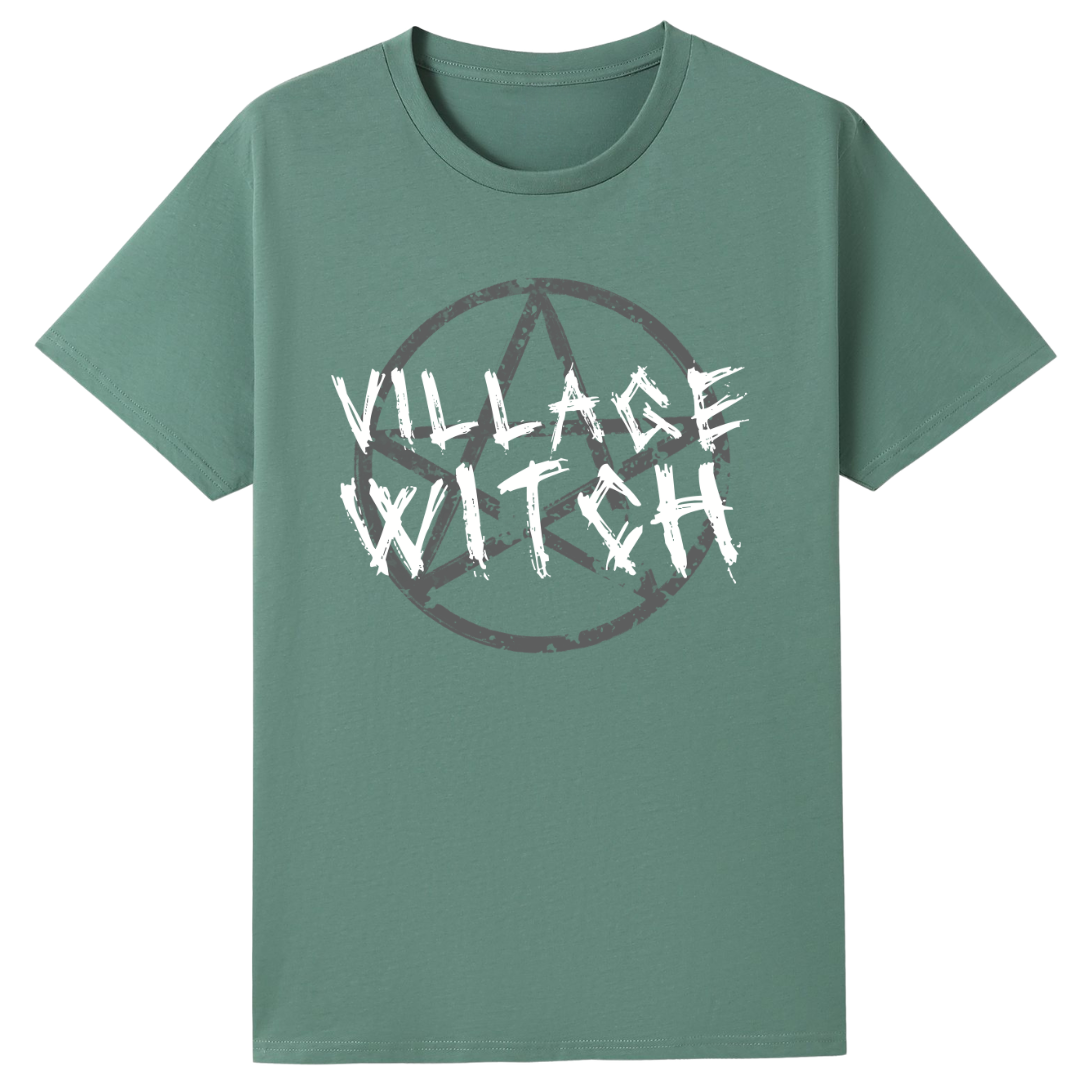 A slate green oversized tee with the Village Witch graphic printed large on the front, scratchy lettering over a weathered pentagram.