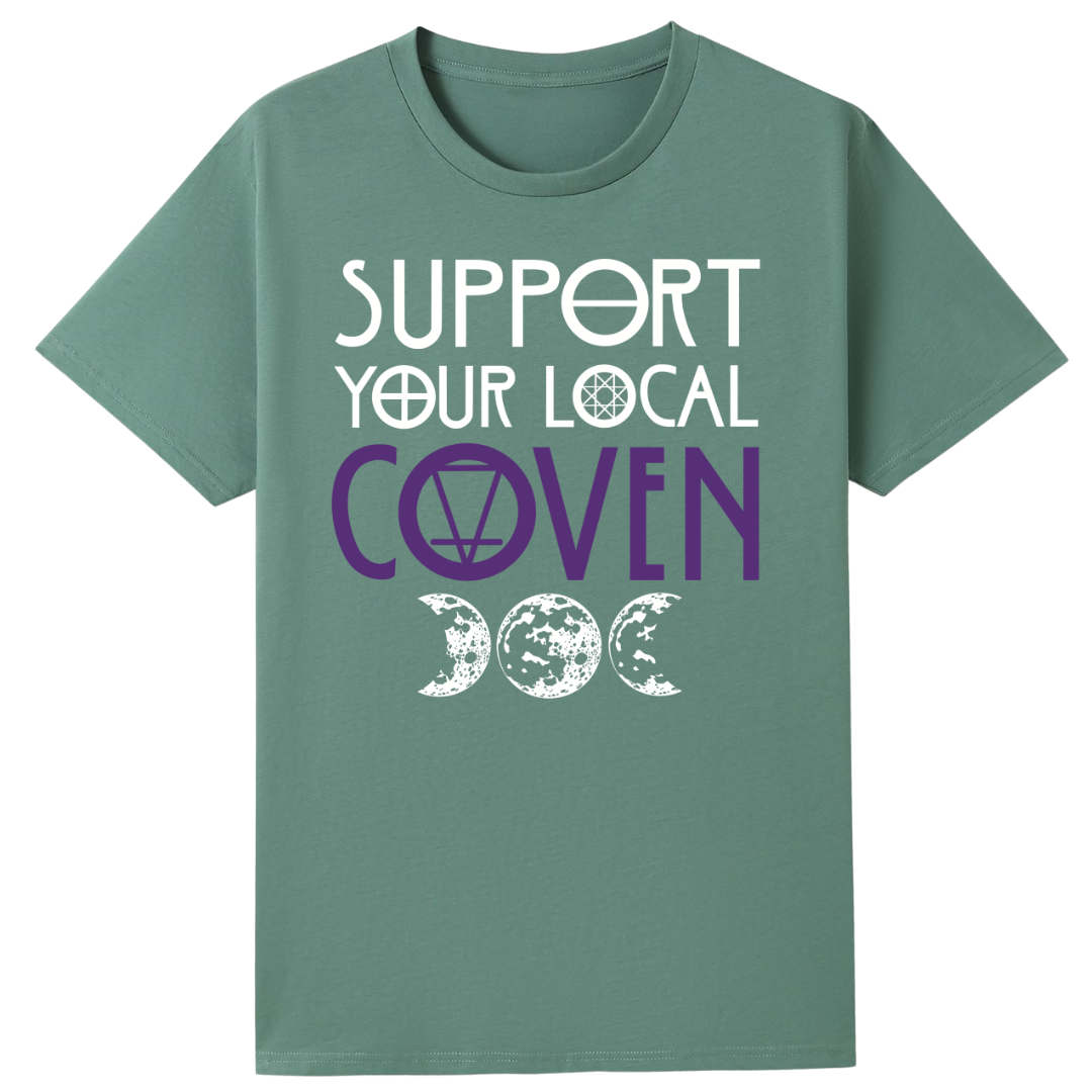 A slate green oversized tee with the Support Your Local Coven graphic printed large on the front, purple lettering above a triple moon.