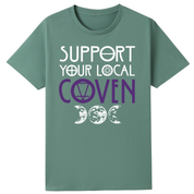 A slate green oversized tee with the Support Your Local Coven graphic printed large on the front, purple lettering above a triple moon.