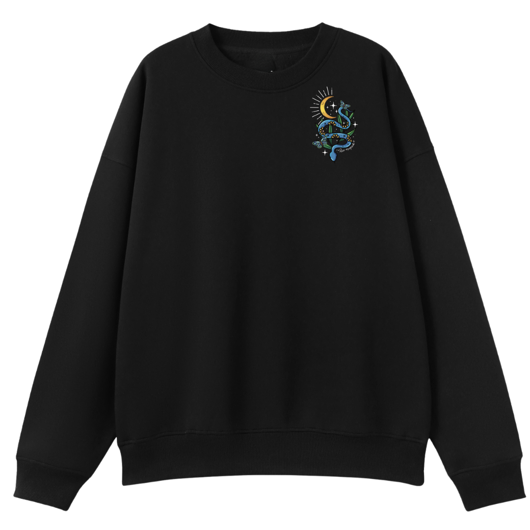 A black oversized crew neck with a small Be Magic snake graphic on the left chest.