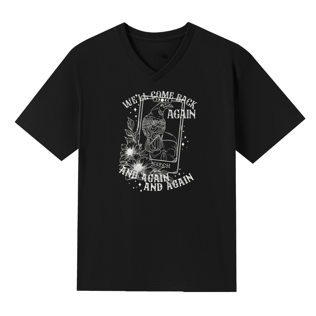 A black V neck oversized tee with the We'll Come Back Again graphic printed large on the front, a crow on a tarot card framed by flowers.