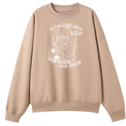 A peach oversized crew neck with the We'll Come Back Again graphic printed large on the front, a crow on a tarot card framed by flowers.