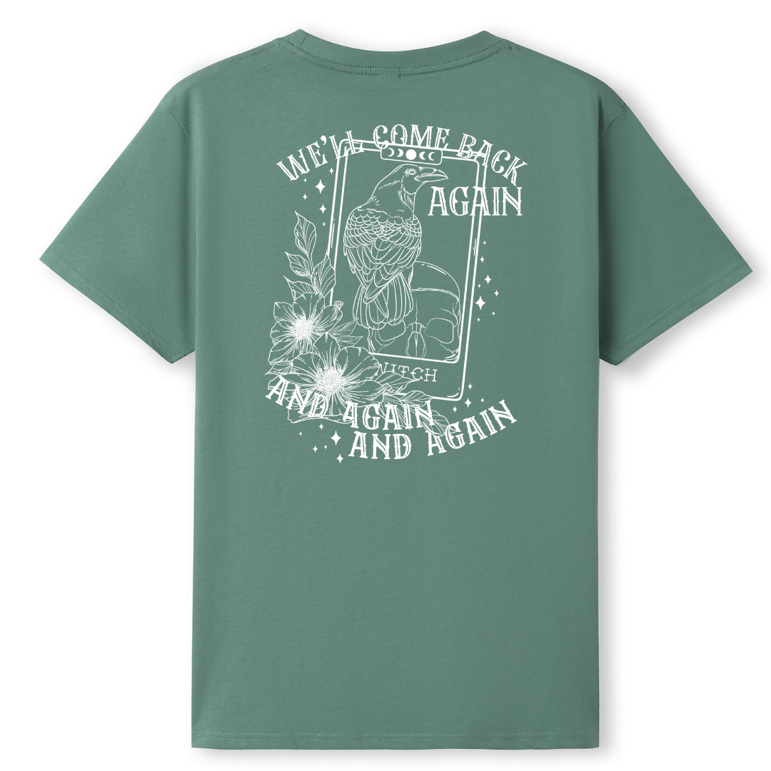 A slate green oversized tee shown from the back, with the We'll Come Back Again graphic printed large across the back, a crow on a tarot card framed by flowers.