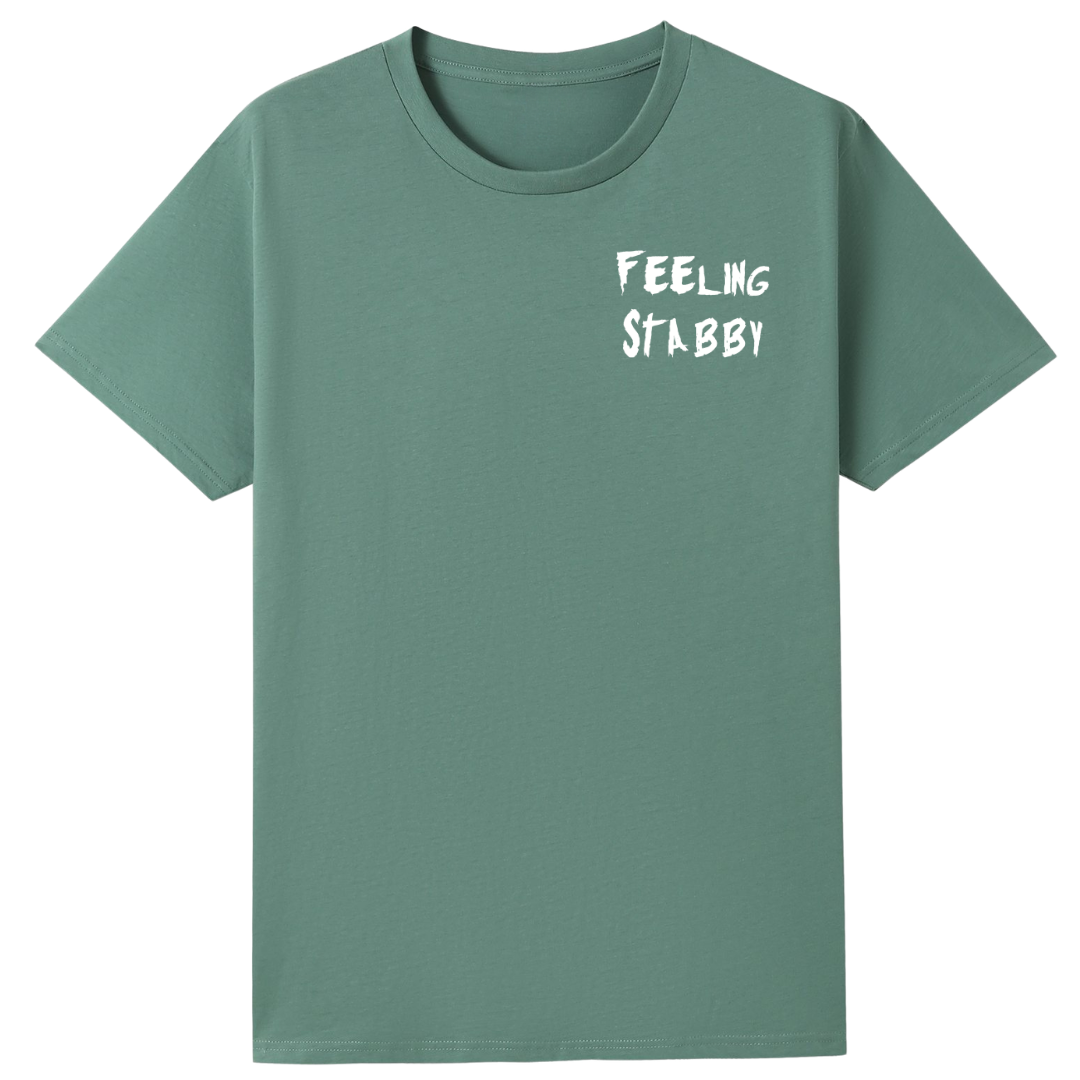 A slate green oversized tee with a small Feeling Stabby graphic on the left chest.