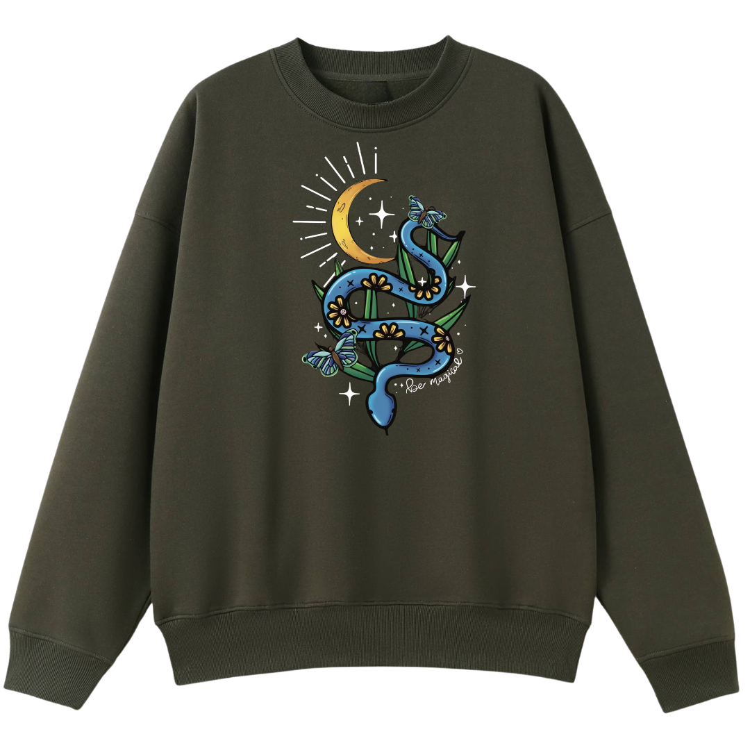 An army green oversized crew neck with the Be Magic snake graphic printed large on the front, a blue floral snake with butterflies under a crescent moon.