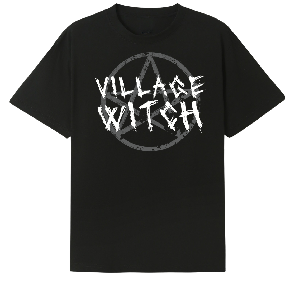 A black oversized tee with the Village Witch graphic printed large on the front, scratchy lettering over a weathered pentagram.