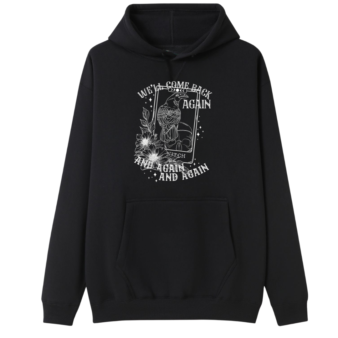 A black oversized hoodie with the We'll Come Back Again graphic printed large on the front, a crow on a tarot card framed by flowers.