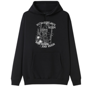 A black oversized hoodie with the We'll Come Back Again graphic printed large on the front, a crow on a tarot card framed by flowers.