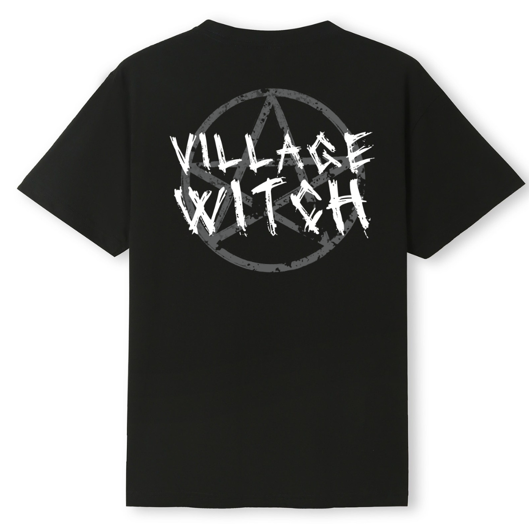 A black oversized tee shown from the back, with the Village Witch graphic printed large across the back, scratchy lettering over a weathered pentagram.