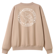 A peach oversized crew neck shown from the back, with the Support Your Local Murder graphic printed large across the back, a crow inside a circular badge.