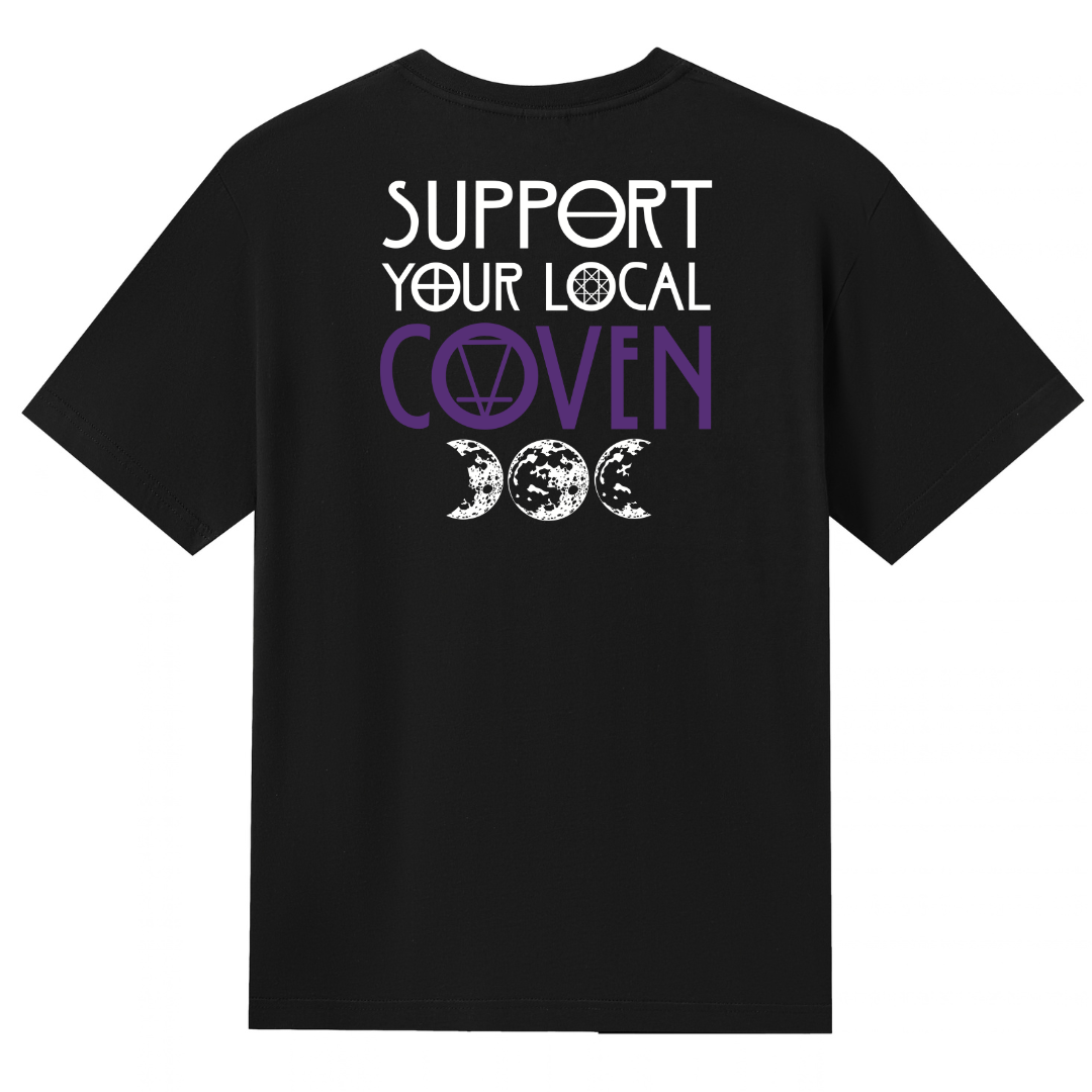 A black V neck oversized tee shown from the back, with the Support Your Local Coven graphic printed large across the back, purple lettering above a triple moon.