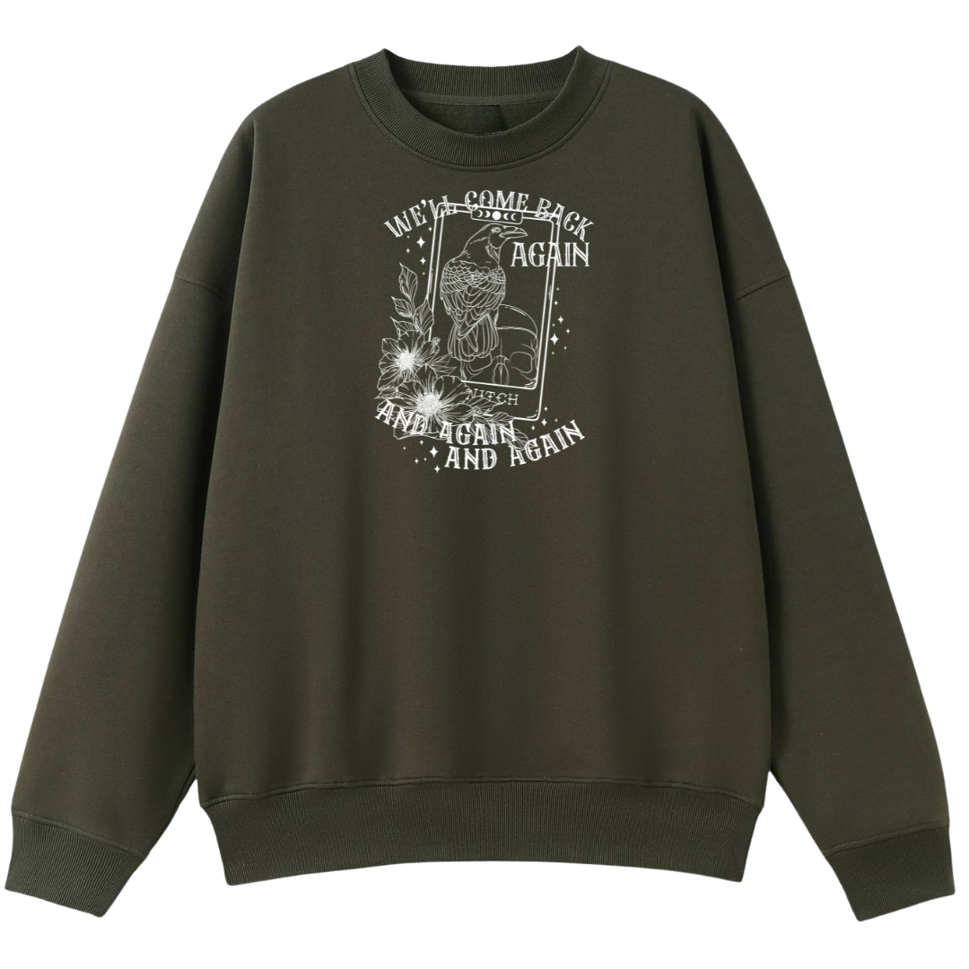 An army green oversized crew neck with the We'll Come Back Again graphic printed large on the front, a crow on a tarot card framed by flowers.